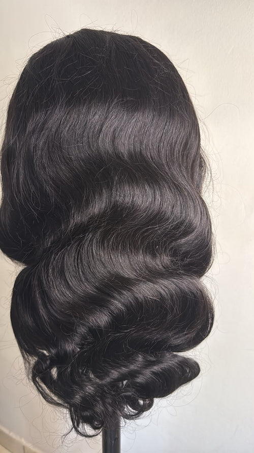 Close-up of glossy natural black body wave human hair, 26 inches